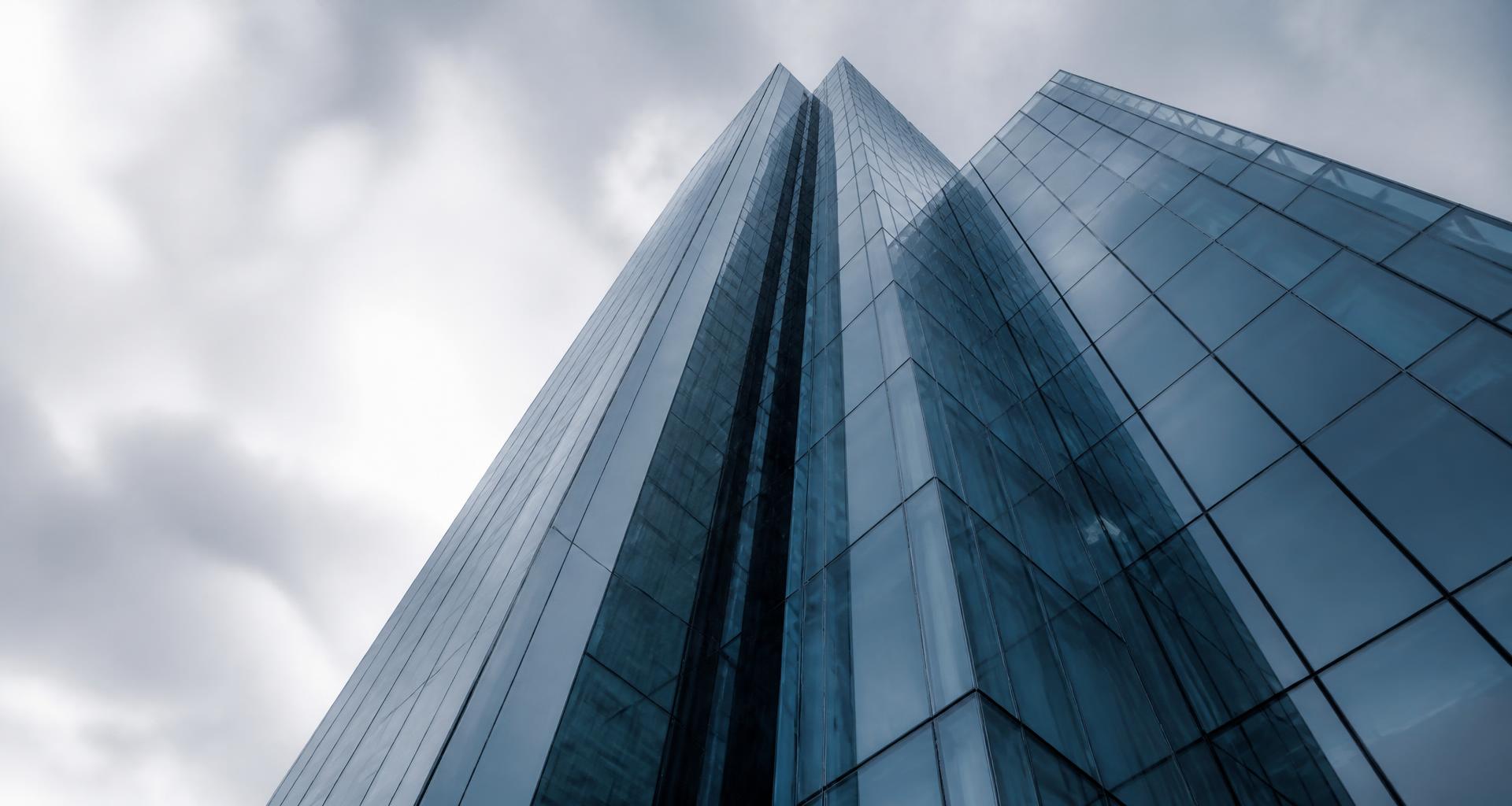 Modern glass tower rising into an overcast sky